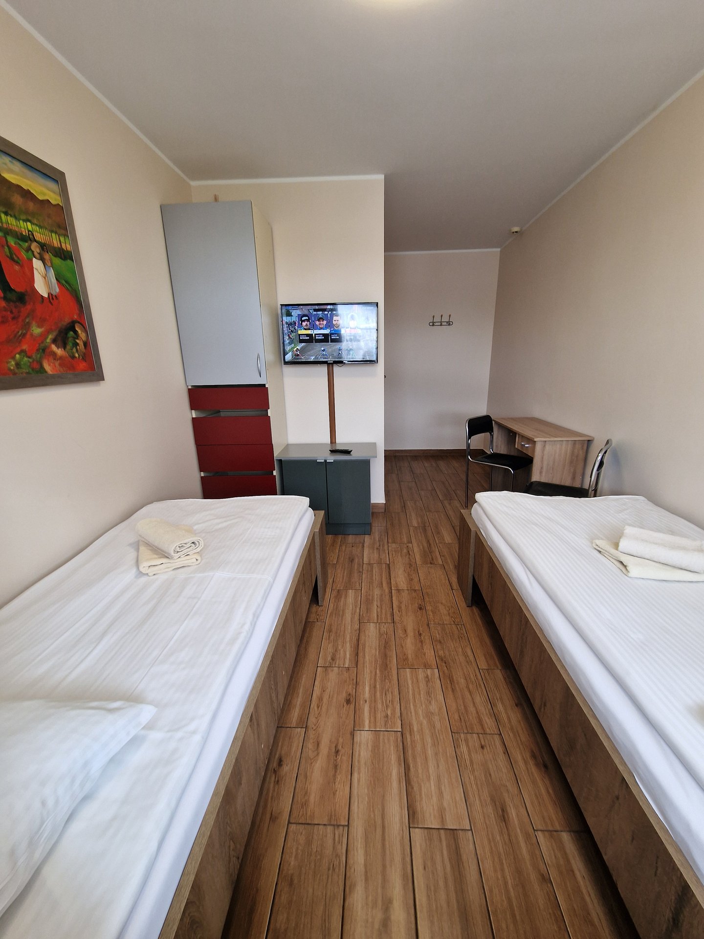 Pokój 2-osobowy — widok na łóżka, telewizor i lodówkę